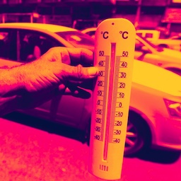 इराक़ की राजधानी बगदाद में एक शख़्स थर्मामीटर में 50 डिग्री सेल्सियस से ज़्यादा तापमान दिखाता हुआ