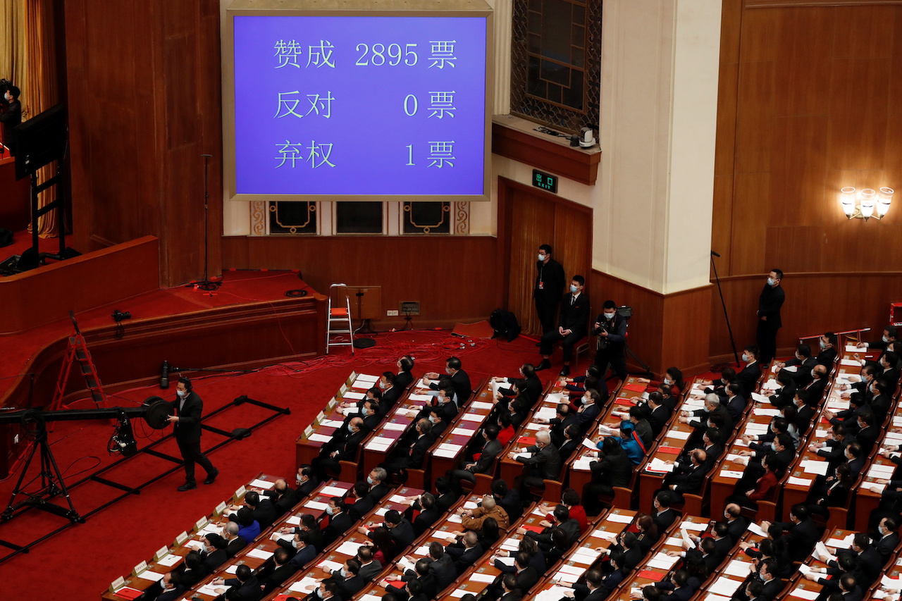 北京人民大會堂內一面巨型電視屏幕顯示中國全國人大表決「完善」香港選舉制度決定結果（11/3/2021）