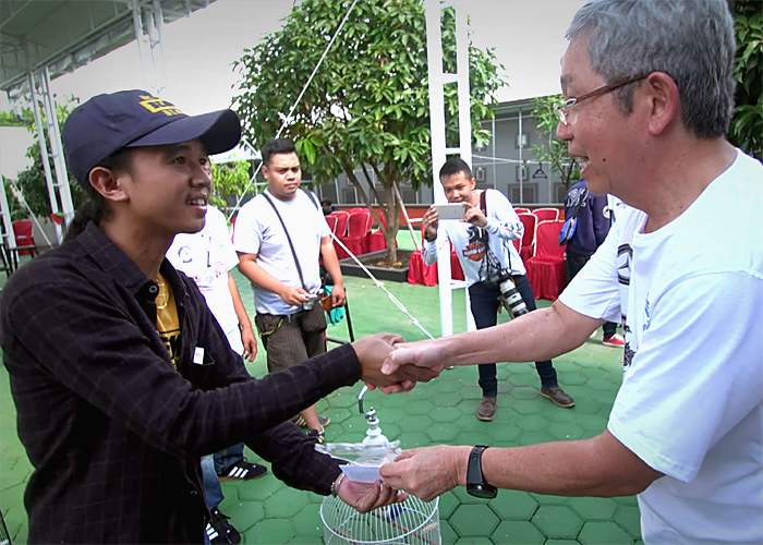 Tony Sumampau presents a prize to a winner