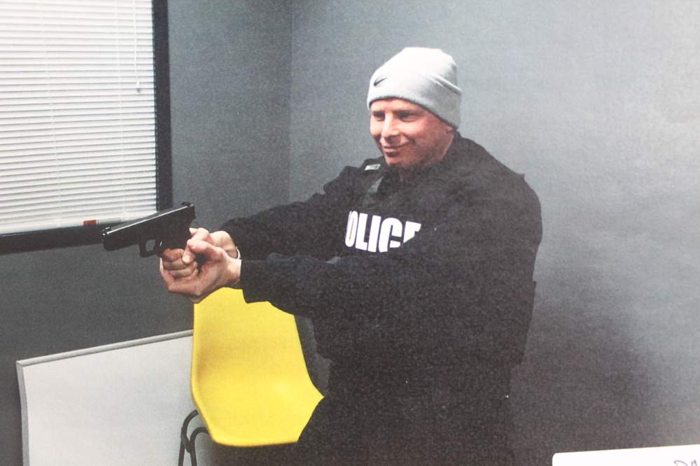 Stepp wears Jenkins&#39; vest and holds his gun at BPD headquarters.