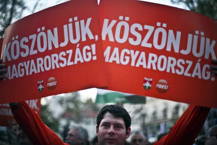 2010: A Fidesz supporter carries a banner reading “Thank you Hungary”