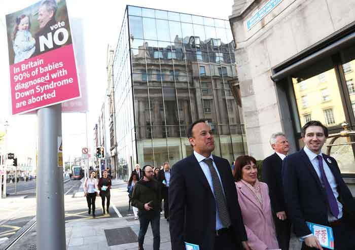 The Taoiseach, Leo Varadkar, passes a Vote-No poster