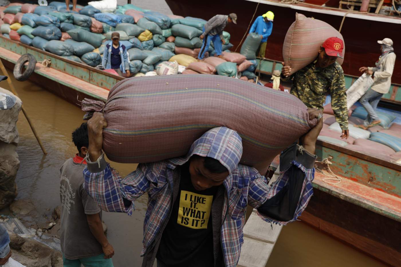 ชาวลาวแบกกระสอบข้าวเปลือกจากเรือที่ขนส่งมาทางแม่น้ำโขงจากเมืองปากแบงขึ้นที่ท่าเรือดอนใหม่ แขวงหลวงพระบาง สปป.ลาว 