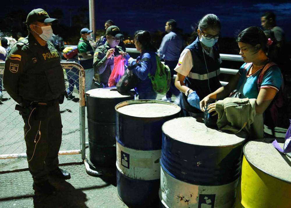 Venezolanos pasan a través de un punto migratorio. Venezolanos pasan a través de un punto migratorio.