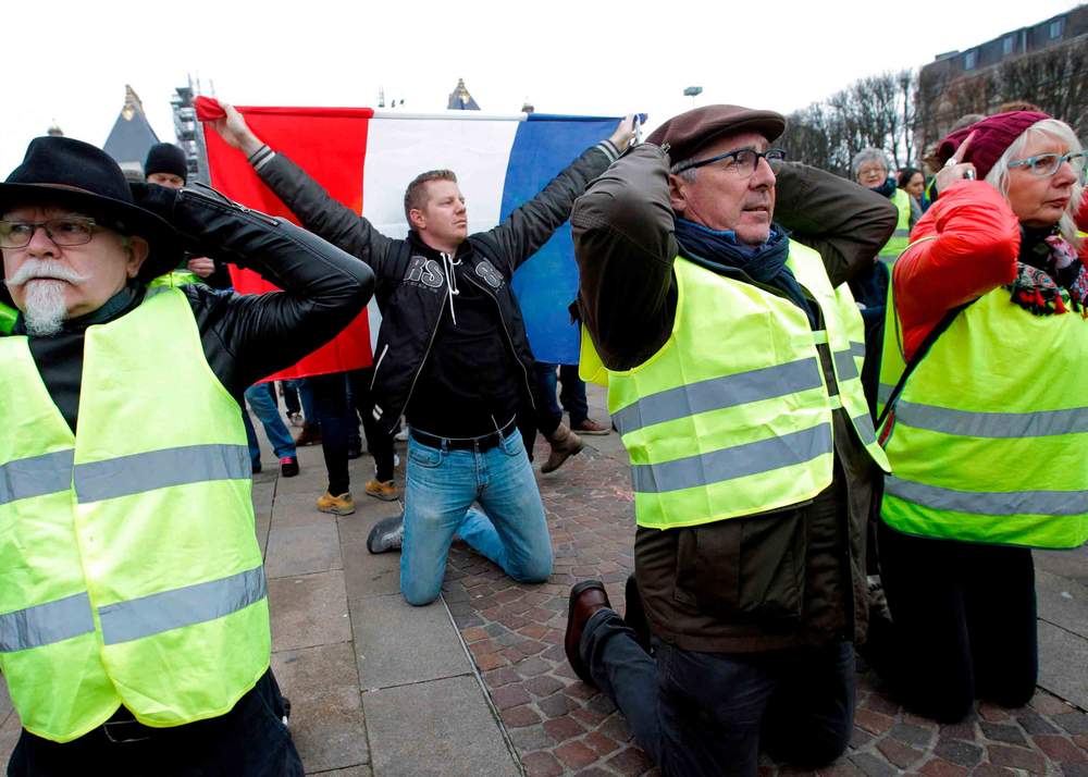 Protesters demonstrate on their knees against rising costs of living in Lille