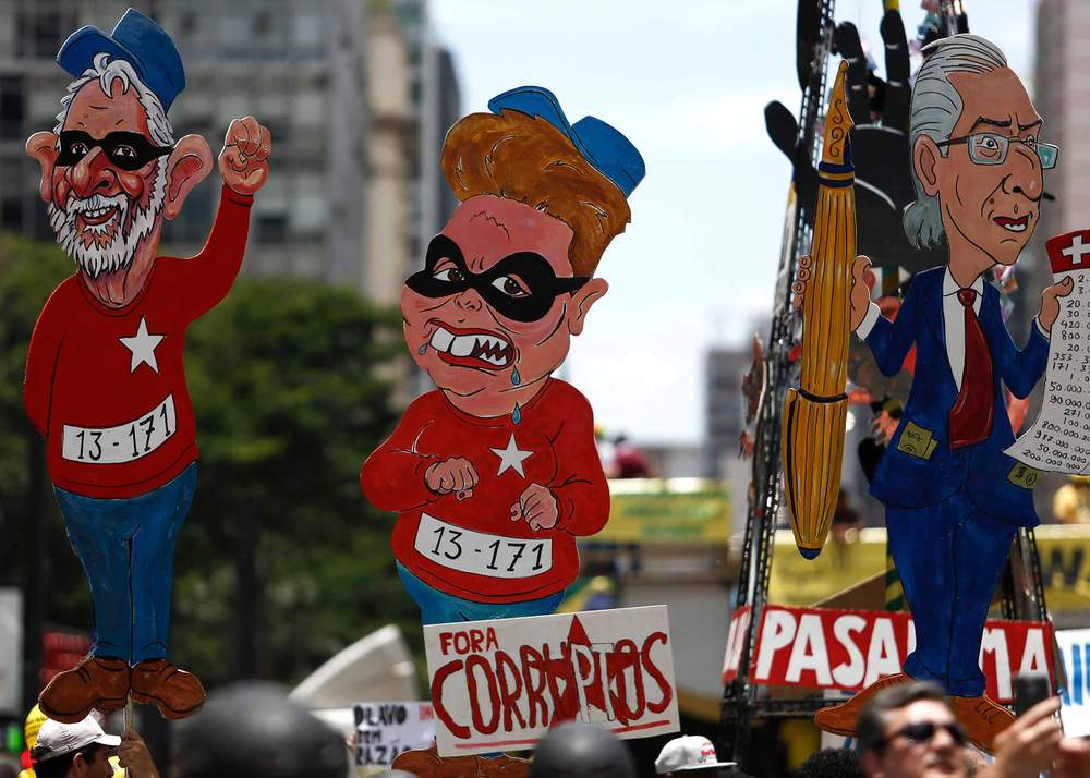 Cartazes com desenho de Lula, Dilma e o ex-presidente da Câmara dos Deputados, Eduardo Cunha (MDB), em um protesto pró-impeachment da presidente petista em São Paulo, 2015