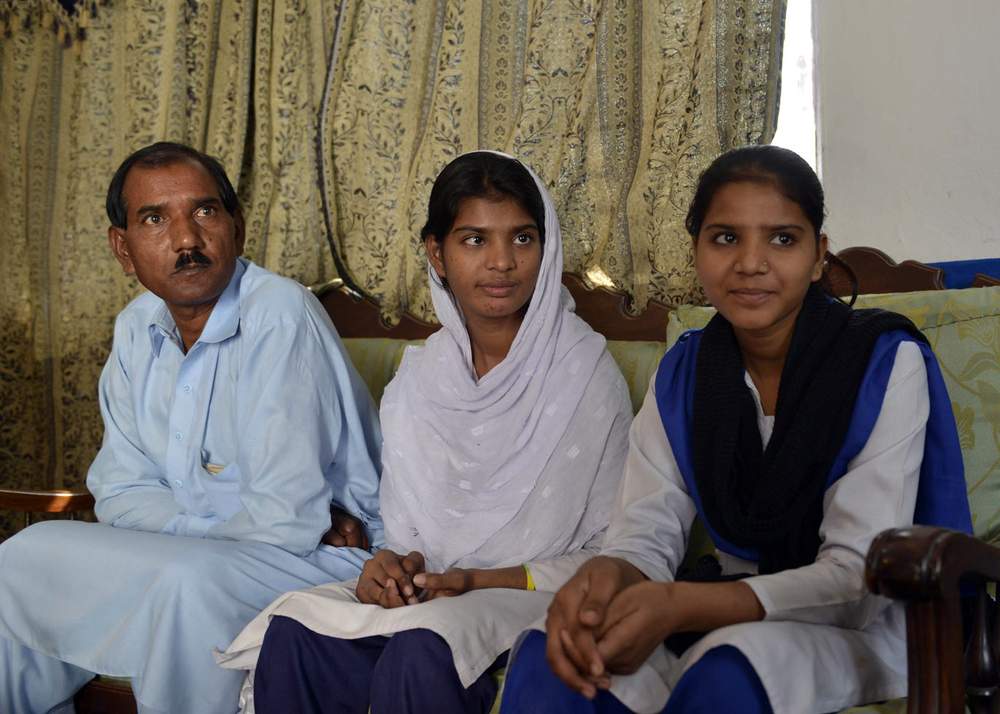 Asia&#39;s husband Ashiq Masih (L) sits with daughters Esham (R) and Esha (C)&amp;nbsp;