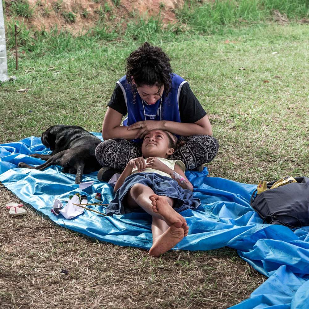 A volunteer sits with one of the many children left homeless