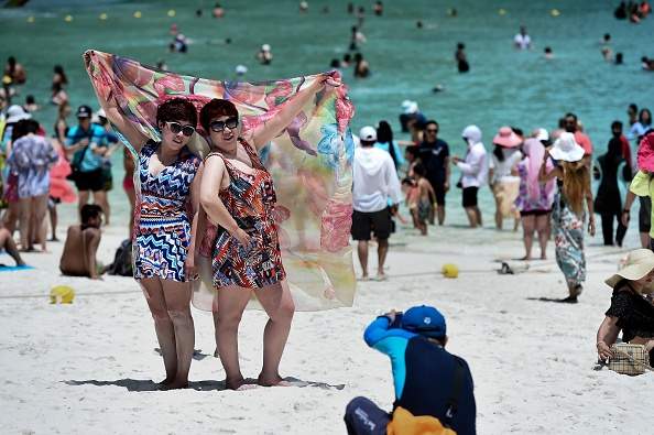 Guia tira foto de turistas na praia de Maya Bay antes do fechamento Guia tira foto de turistas na praia de Maya Bay antes do fechamento