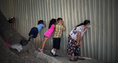 Muro da prisão de Ilopango, em San Salvador, por onde pessoas tentam identificar seus familiares.