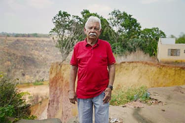 Foto de José Ribamar Silveira ao lado de uma voçoroca