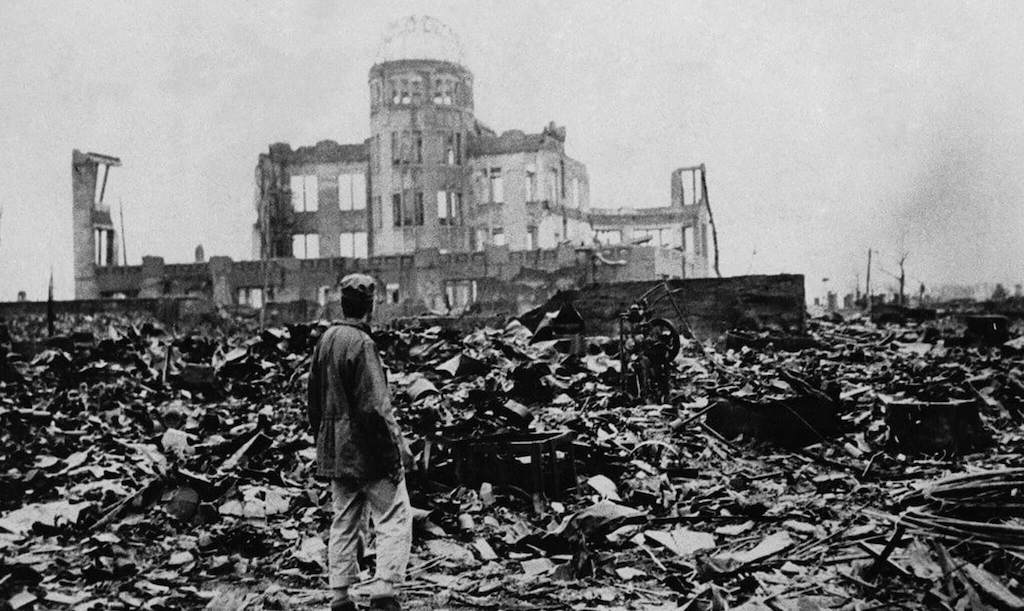 Un hombre parado ante un edificio destruido en Hiroshima
