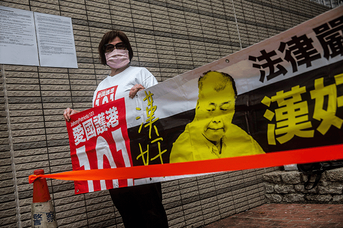 一位親中國政府示威者在香港西九龍法院大樓外拉起指罵黎智英為「漢奸」的橫幅