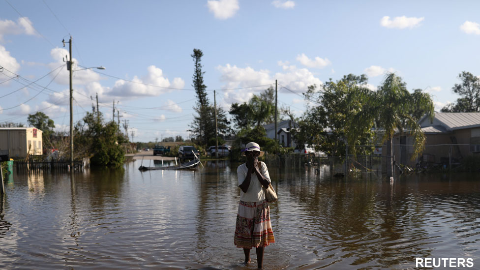 Maria Dorsaint wipes sweat from her face on the way to her church, Haitian United Evangelical Mission, which was damaged by flooding from Hurricane Irma in Immokalee, Florida